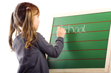 a beautiful little girl is writing the word school on a board - 10934634