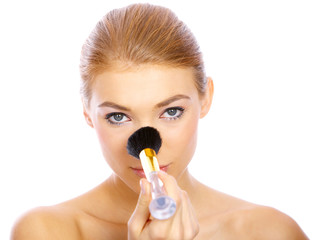 Portrait of beautiful blond woman doing makeup, on white