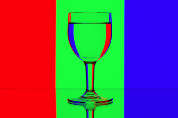 domino wine glasses in backlight on the red, blue and green cont