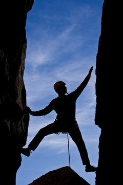 Rock climber reaching.
