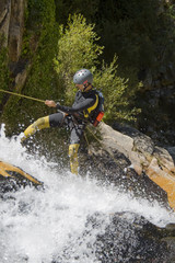 Men descending waterfall in rappel