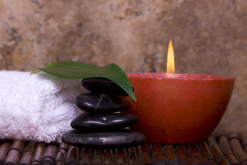 Obraz na płótnie Canvas Balanced pebble rocks, candle, white towel set on bamboo