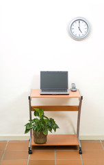 Office desk, laptop and clock