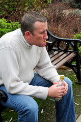 depressed man with empty alcohol bottle