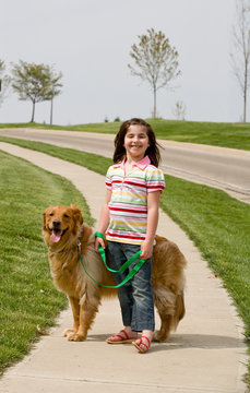 Girl Walking Down The Sidewalk With Dog