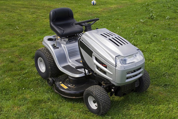 Fototapeta na wymiar Small silver tractor for cutting lawn.