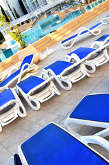 Empty chairs by the pool of  hotel