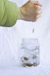 monete che cadoo in un barattolo di vetro con acqua  2