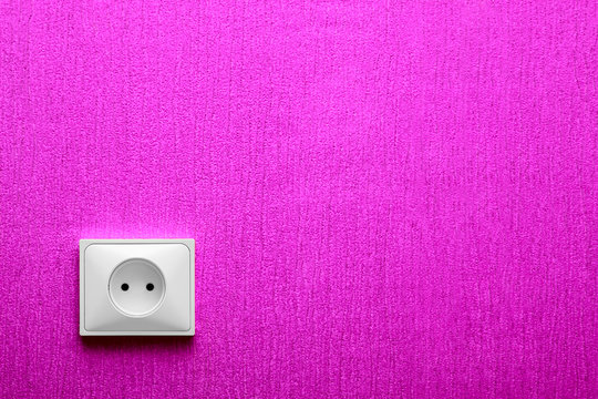 The electric socket in a pink wall