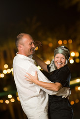 Middle-aged couple dancing waltz at night