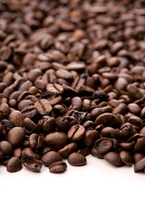 Viele Kaffebohnen auf weißem Untergrund