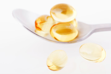 Fototapeta na wymiar Makro kiści żółtych tabletek żelowych na łyżce