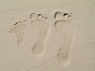 empreintes de pied sur le sable blanc