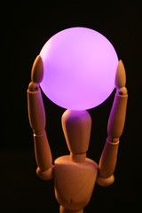 wooden mannequin holding  pink light ball on head