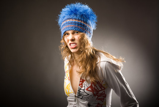 Agressive young beautiful sporty girl in blue winter cap