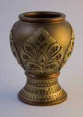 Beautiful golden clay vase on a white background