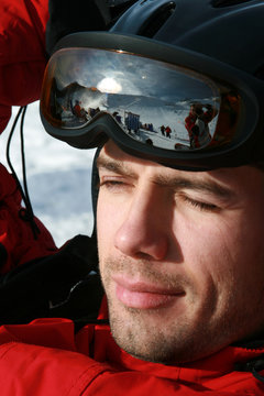 Male skier wearing helmet and goggles, close-up