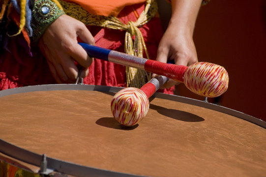 Women playing the orange drum.