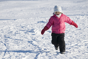 Fototapeta na wymiar Little girl playing at winter time
