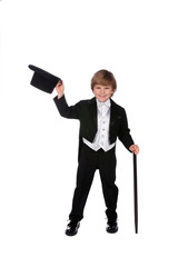 playful young boy in black tux lifting off his hat