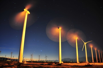 Windfarm with blades moving at sunrise