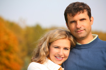 Fototapeta premium The husband embraces the wife in autumn park