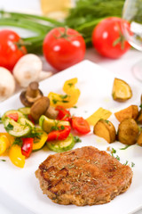 rumsteak with roasted potatoes, fried vegetables and mushrooms