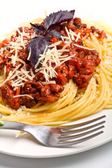Spaghetti bolognese with grated cheese and basil