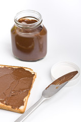 chocolate spread container with a buttered toast and a knife