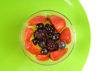 Glass of berries on green plate