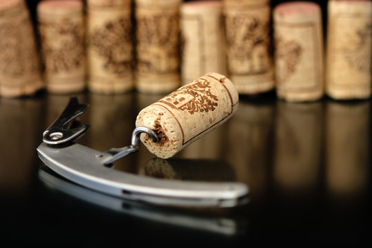 Corkscrew with corks on background