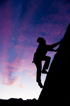 Rock climber clinging to an overhang.