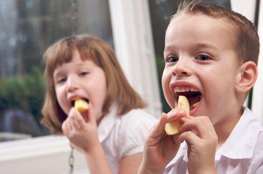 Young Siblings Eating An Apple