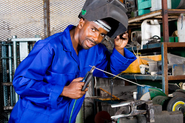 african welder working on metal work