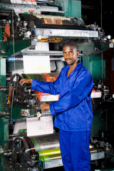 operator standing next to an old printing press