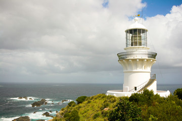 Fototapeta na wymiar White lighthouse on the shore