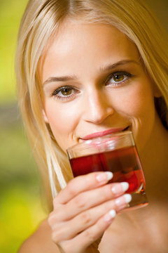 Young beautiful woman with glass of juice, indoors