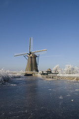 Frozen river with windmill in Holland