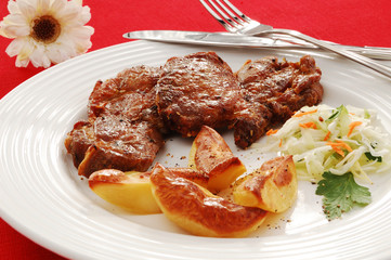 Grilled meat with baked potatoes and vegetable salad