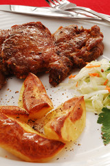Grilled meat with baked potatoes and vegetable salad