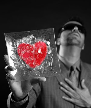 Broken red glass heart businessman metaphor