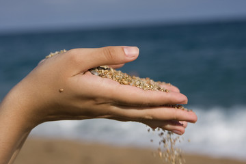 close up of a open hand with little stones over blue sky and oce