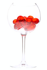 red jelly hearts in wine glass over white background