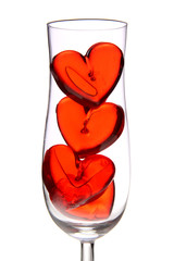 red jelly hearts in champagne glass over white background