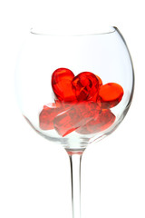 red jelly hearts in wine glass over white background