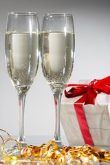 Glasses of champagne, gifts with red tapes and bows