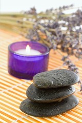 Fototapeta na wymiar Pebbles, candle and lavender. Time to relax.