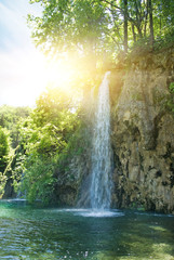 Sunrise over waterfall in wild forest