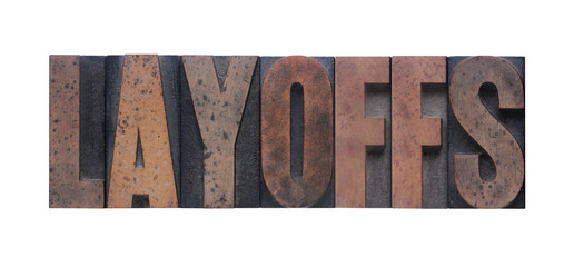 the word 'layoffs' in old ink-stained wood type