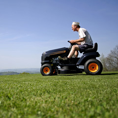 man sitting on a lawnmower - 11401238